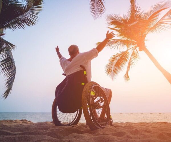 Disabled man in a wheelchair on the beach. Concept background