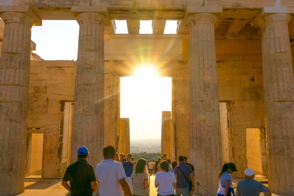 Greece. Sunset over summer Athens. Tourists at the entrance portico to the Parthenon